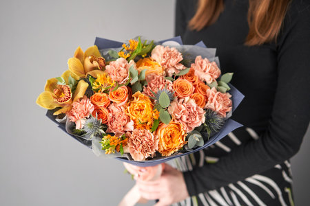 Beautiful bouquet of flowers in woman hand. Floral shop concept . Beautiful fresh cut bouquet. Flowers deliveryの写真素材