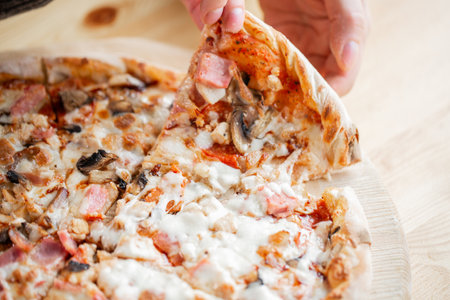 one people taking slices of pizza out of the box. fast delivery of food. packaging for fast food. top viewの写真素材