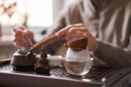 Tea master pours white tea to guests. Everything is ready for the tea ceremony. The ceremony is according to all the rules, but not in the classical style. Adapted to a modern apartment.の写真素材