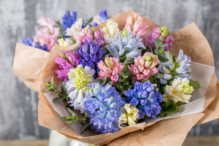 Small Beautiful bouquet of mixed flowers in woman hand. Floral shop concept . Beautiful fresh cut bouquet. Flowers deliveryの写真素材