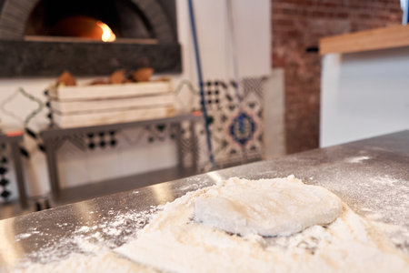 pizza dough in the foreground. A wood-burning stove in the background. Neapolitan pizza.