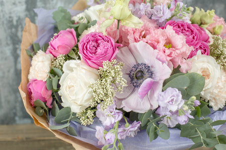 Small Beautiful bouquet of mixed flowers in woman hand. Floral shop concept . Beautiful fresh cut bouquet. Flowers deliveryの写真素材