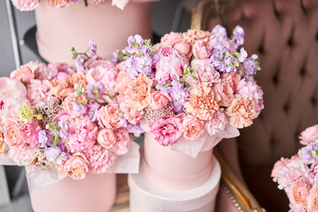 Flowers as a gift to your beloved woman. A gift set of boxes with flowers in a beautiful interior on the background of a sofa. The flower room. A box of flowers for Mothers Day.の写真素材