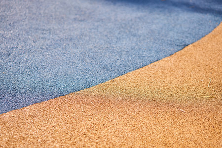Special rubber coating for the playground or sports activity. Junction of multicolored pieces of floor covering made of recycled materials. Padded floor covering with rubber granules.の写真素材