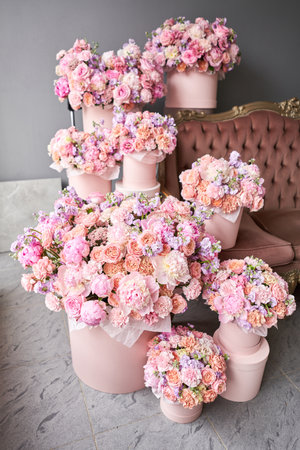 Flowers as a gift to your beloved woman. A gift set of boxes with flowers in a beautiful interior on the background of a sofa. The flower room. A box of flowers for Mothers Day.の写真素材