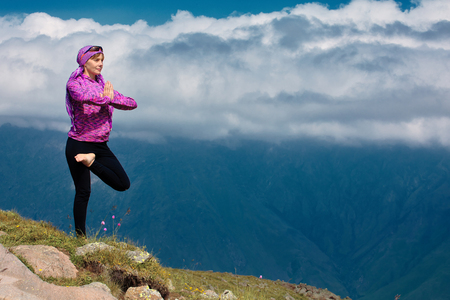 Woman doing yoga in beautiful mountainsの写真素材