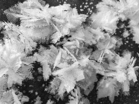 black-white patterns of snowflakes and ice crystals of air on the surface of the ice. Abstract...