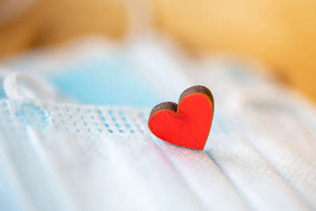 Medical mask as a gift for Valentine's Day. Red heart and blue maskの写真素材