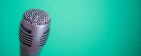 Clubhouse podcast green banner with studio microphone and light wave. Professional broadcast microphone recording sound with waveform signal on green backgroundの写真素材