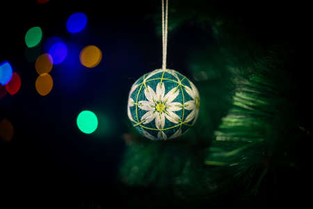 Christmas New Year's handmade toy hangs on a green spruce branch. Ball braided from threadsの写真素材