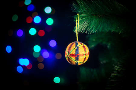 Christmas New Year's handmade toy hangs on a green spruce branch. Ball braided from threadsの写真素材