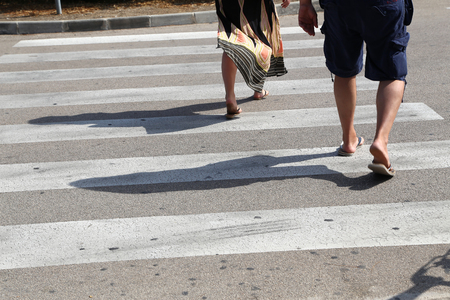 Close-up of people walking on the zebra crossing to cross the road safely.の写真素材