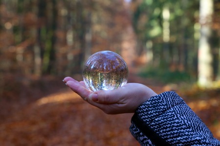 Autumn through a glass ball. Autumn compositions with glass bowl
