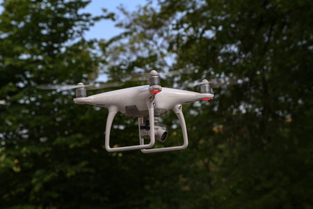 Flying quadcopter with digital camera on blurred background.の写真素材