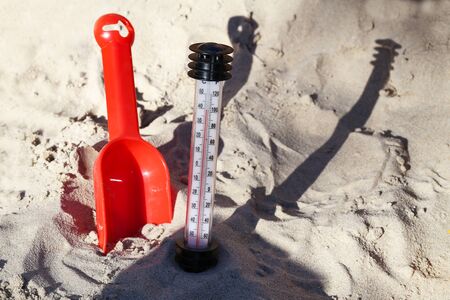 Hot Summer. Thermometer in the sand on the beach.