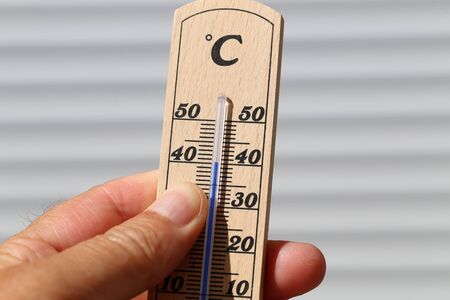 Hot Summer - Thermometer in hand, shows the heat.の写真素材