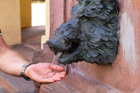 Cold water pours trickle from city well.の写真素材