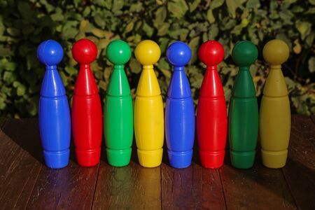 Colorful plastic toy bowling pins on wooden floor close upの写真素材