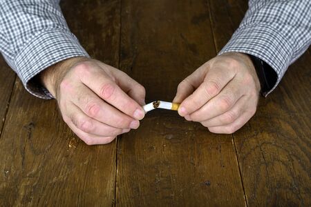 Broken cigarette with a filter in hand.の写真素材