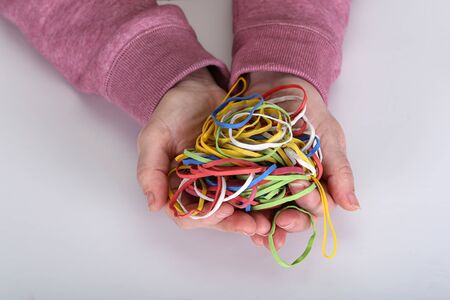 Many colored elastic bands in the hands.