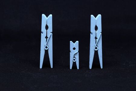 Blue wooden clothespins on a black background