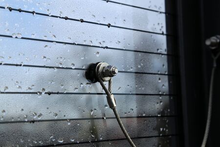 Glass fixed with a metal cable and bolt with nut