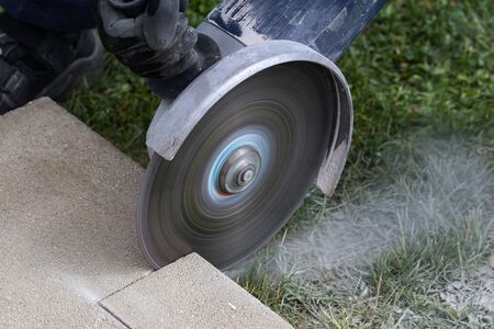 Industrial construction worker using a professional angle grinder.