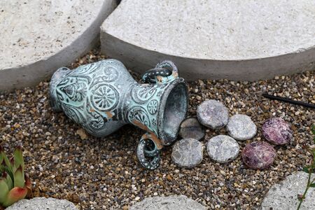 Decorative jug with lying colored pebbles garden decoration.の写真素材