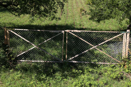 Gate of wooden frames covered with wire mesh.