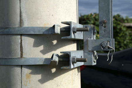 Clamps with fixing bolts on an electric pylon.