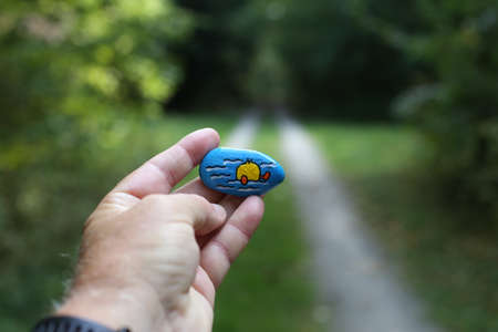 A painted hiking stone is left on the walking path for passersby to see.の写真素材