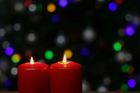 Burning red advent candles on dark background