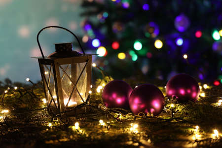 Christmas still life with bright Christmas garlands and a luminous lantern
