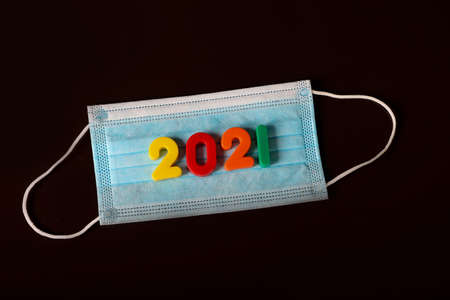 Medical mask and numbers 2021 on dark background.の写真素材