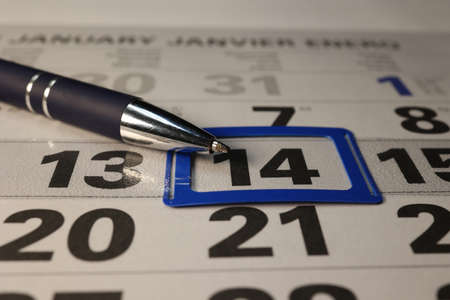 A calendar and a pen lie on the table in the officeの写真素材