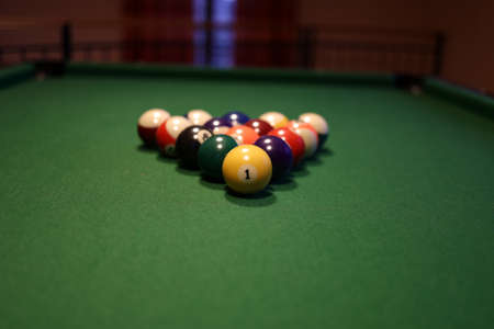 Colored pool balls on a green pool table. Billiard ball with number one.