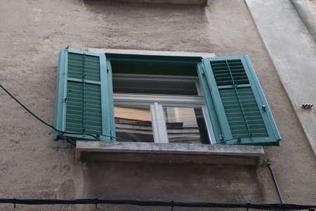Window with green shutters in an old house.の写真素材