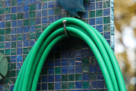 Green hose for watering plants in the gardenの写真素材