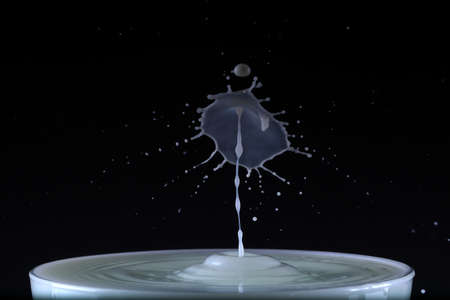 A drop of milk falls into a cupの写真素材