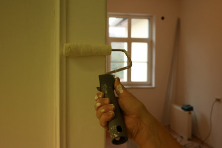 Home repairs. Painting the doorway with a roller.の写真素材