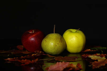 Ripe apples and pears lie on the tableの写真素材