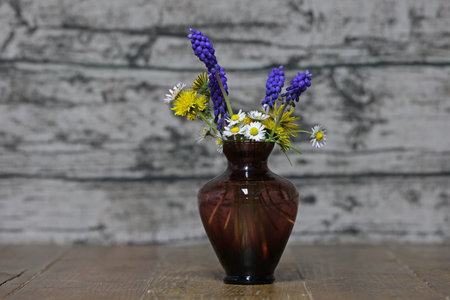 A vase with spring flowers is on the table.の写真素材