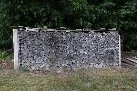 Dry firewood is evenly stacked in the woodpileの写真素材