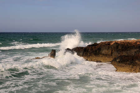 The waves of the sea crash against the rocky coastの写真素材