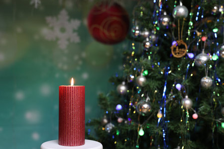 Burning candle on the background of a Christmas treeの写真素材