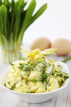salad with ramson and eggs on a wooden boardの写真素材