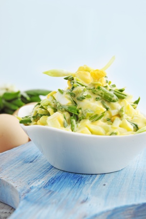 salad with ramson and eggs on a wooden boardの写真素材