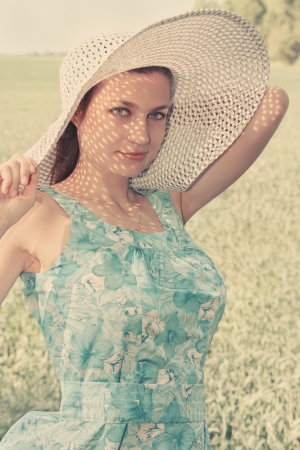 young woman in a big hat on the fieldの写真素材