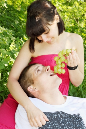 Young beautiful woman is nursing her beloved grapesの写真素材