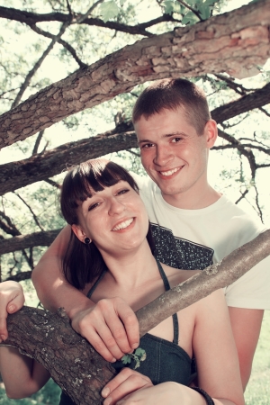 Romantic couple hugging in the woods under a tree.の写真素材